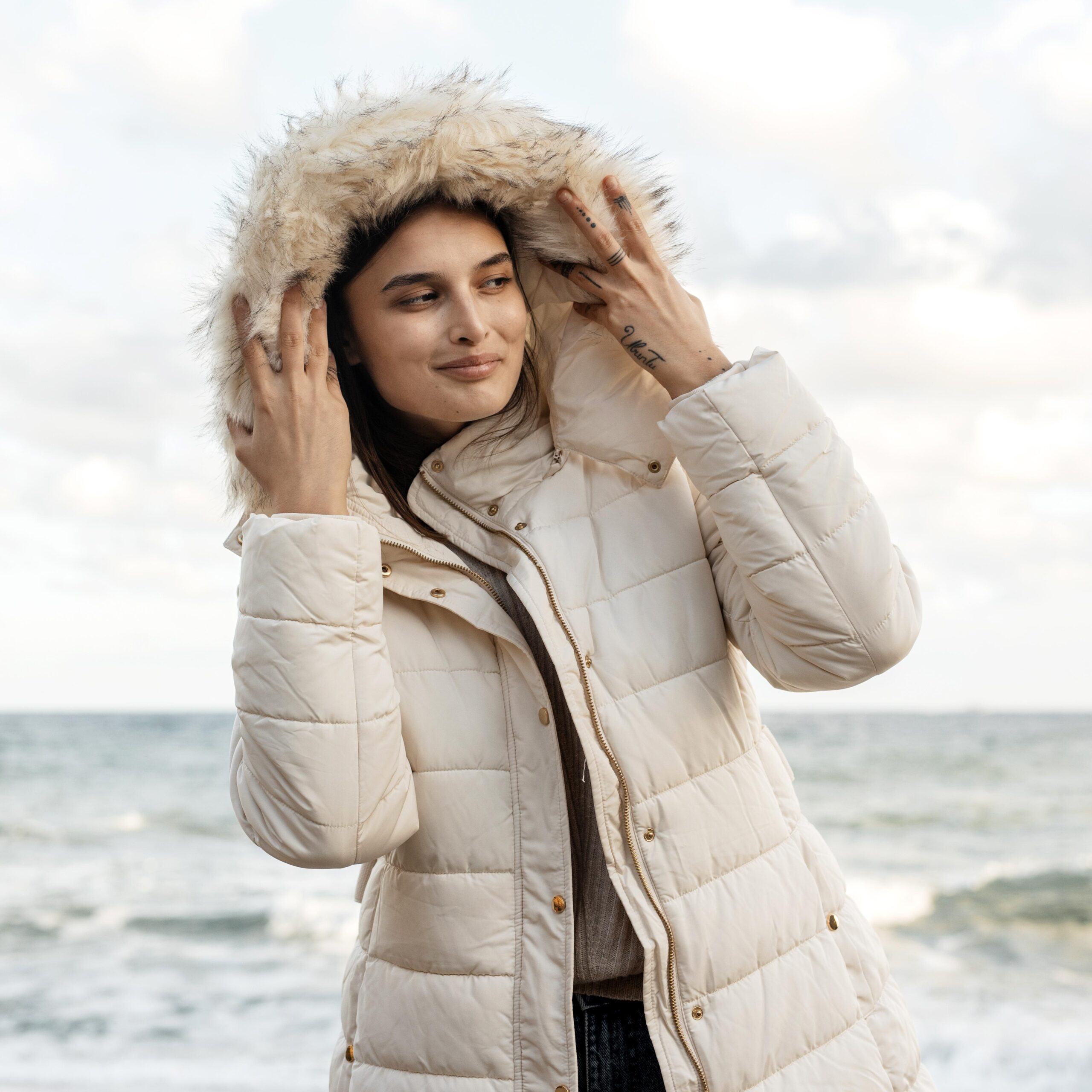 front-view-smiley-woman-beach-with-winter-jacket